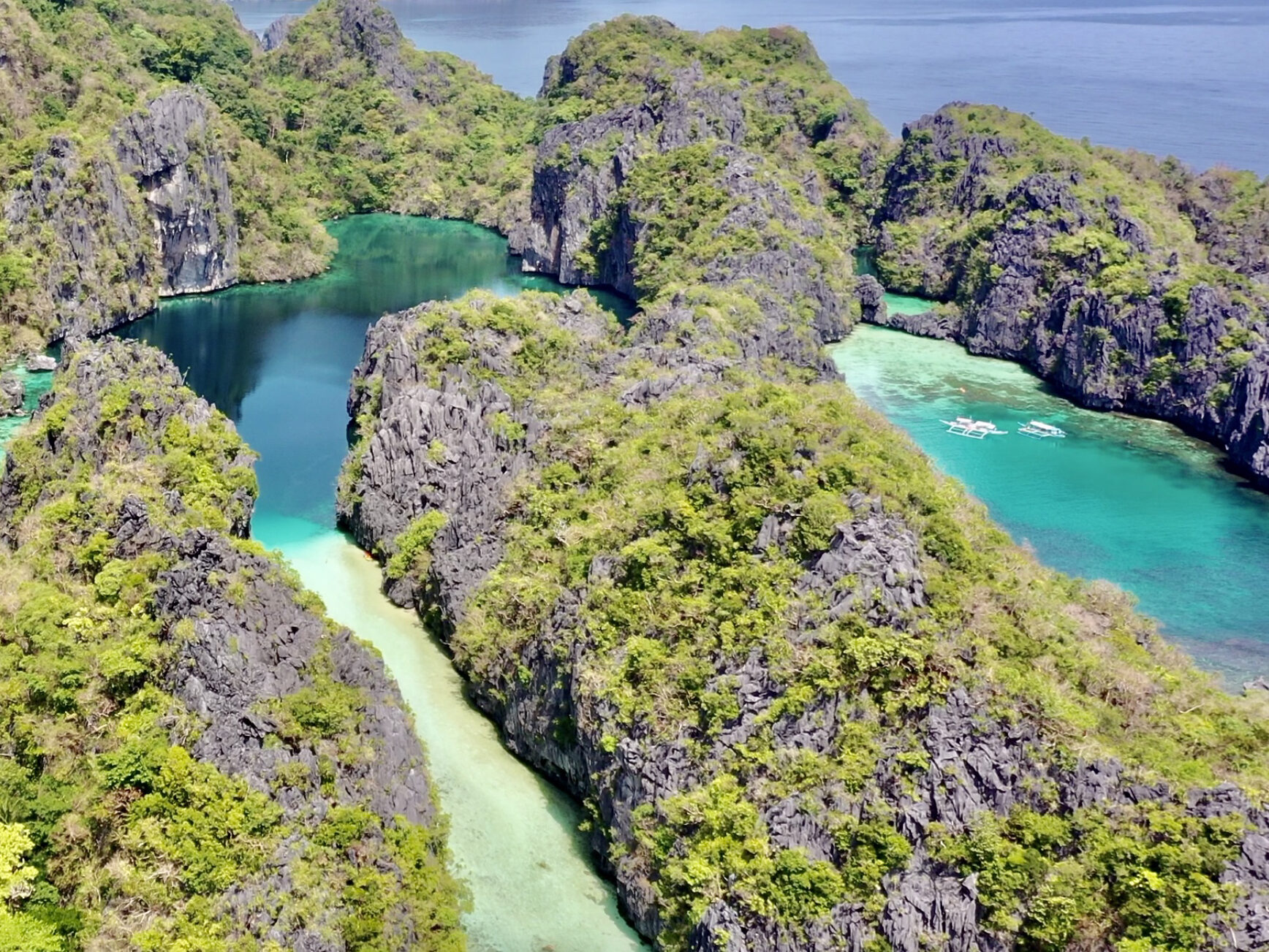 Kayakers paddling between limestone cliffs in Big Lagoon, El Nido