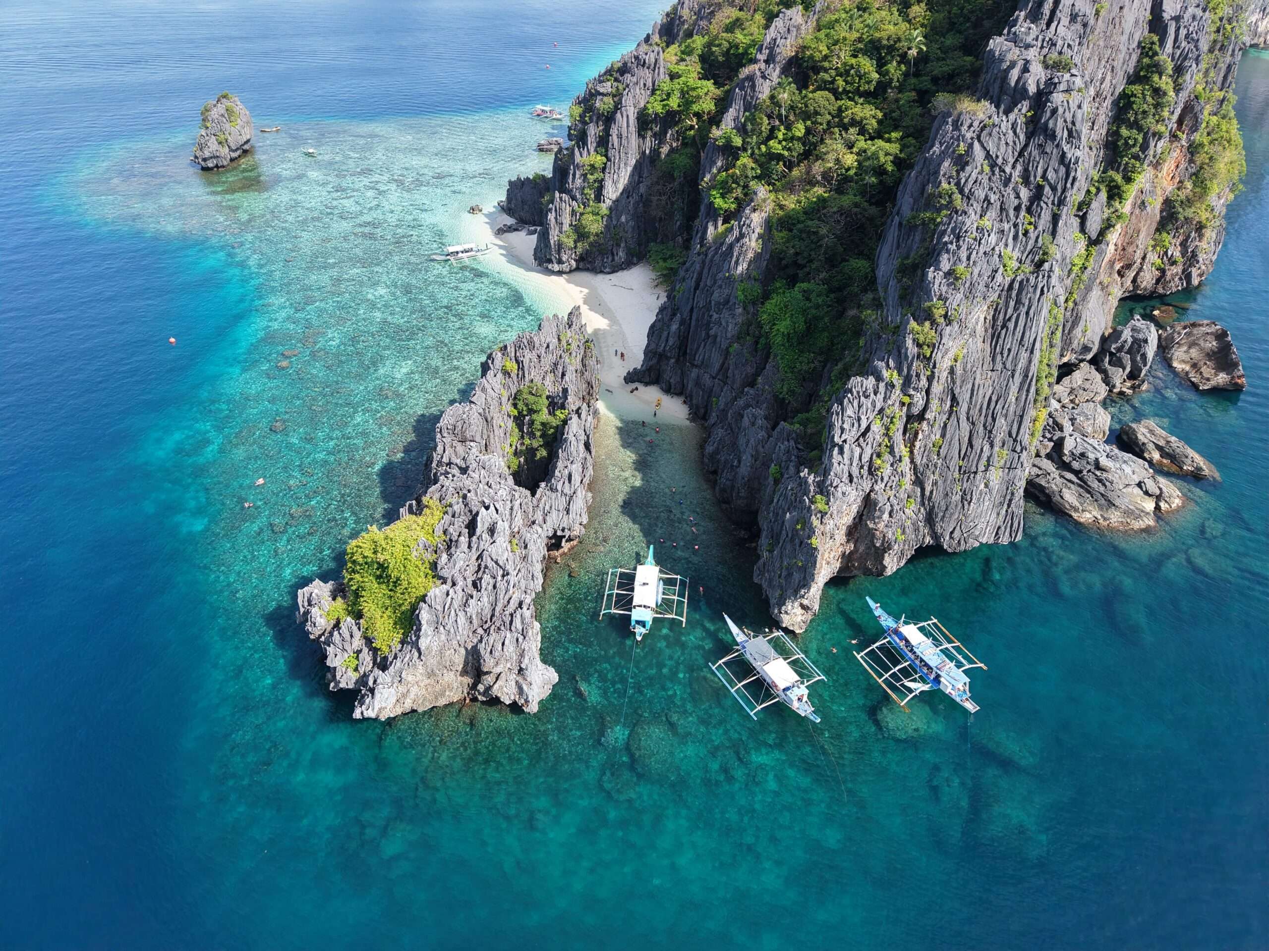 Secluded beach inside Secret Lagoon ringed by towering rocks, El Nido