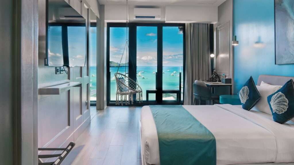 Ocean View room at H Hotel El Nido with floor-to-ceiling windows over El Nido Bay.