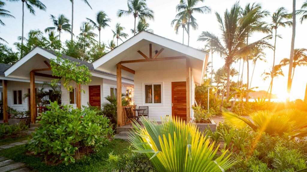 Individual villas at Nacpan Beach Villas among palm trees in late afternoon light, El Nido