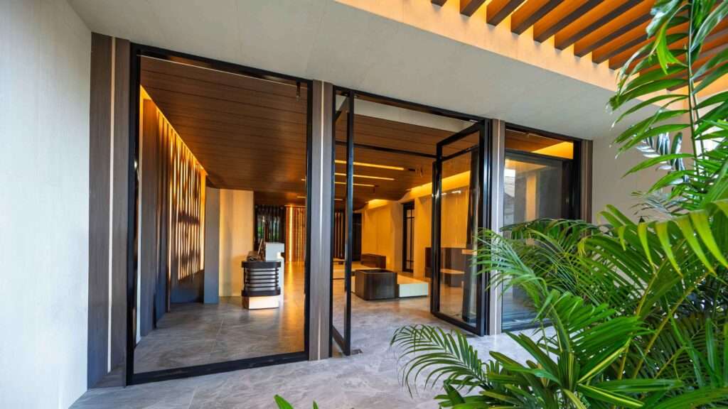 Entrance to S Resort El Nido on Rizal Street, with glass doors and tropical planting