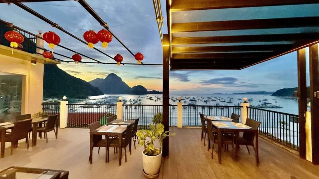 Open-air restaurant terrace at S Resort El Nido with red lanterns overlooking El Nido Bay